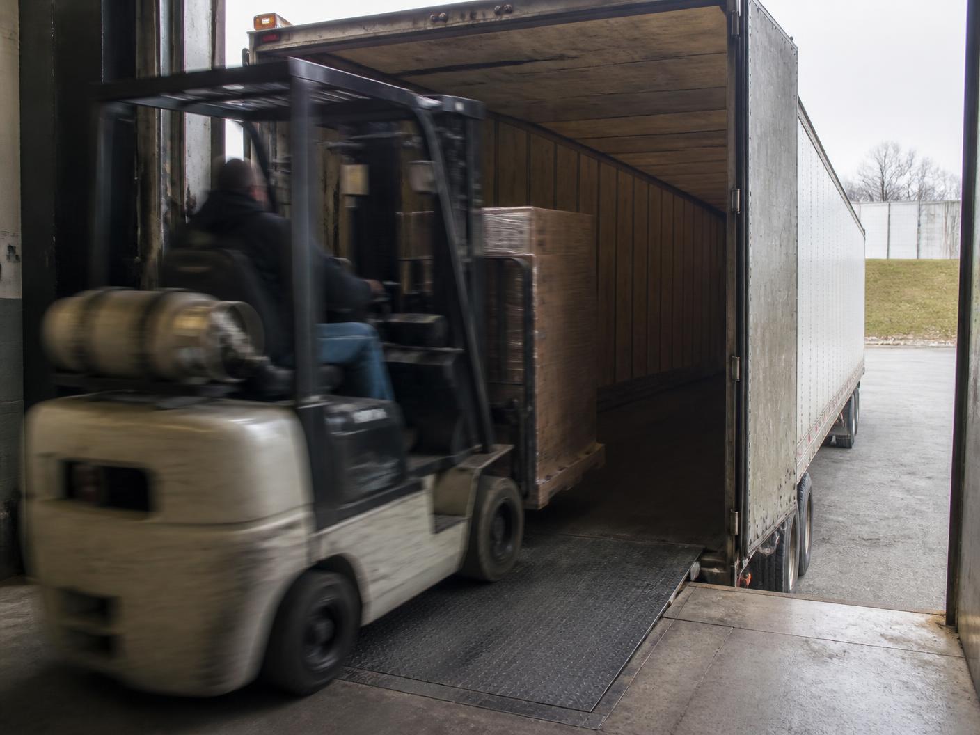 Forklift loading wrapped pallets into a 53 foot trailer