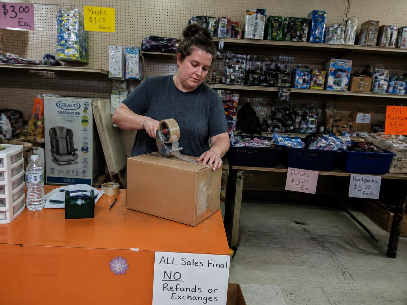 Reseller standing in their discount store stocked from liquidation pallets